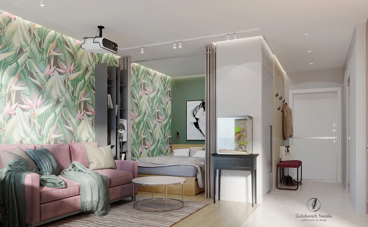 Я логично поделила дизайн интерьера квартиры на три зоны. Открытая зона включает прихожую и объединенное пространство кухни, столовой и гостиной. В приватной части квартиры находится спальня. В третьей –расположился санузел. В этих функциональных зонах разместили узкоспециализированные «островки». Так, на границе столовой и гостиной находится рабочее место, а в гостиной уголок релакса и чтения: раскладной диван, стеллаж для книг и стильный напольный торшер.<br>
Небольшая ширина балкона (около 80 см) не позволила организовать там полноценную зону отдыха. Но незаметный шкаф и элегантный барный стул делают и это помещение полифункциональным. <br><br>

Открытая планировка, большие симметричные окна и выбранная цветовая гамма придают интерьеру ощущение воздушности. Светлые цвета сочетаются с яркой стеной с пальмовыми цветами в гостиной и зеленой краской в зоне отдыха и создают эффект «акварельного» интерьера: где-то прохладного, где-то теплого, но везде ненавязчивого, прозрачного и свежего. <br>
В данном интерьере сочетаются материалы разной фактуры: холодный блеск керамической плитки, теплая матовость окрашенных стен, яркие обои KT-Exclusive Palm spring. <br><br>

Интерьер получился просторным, функциональным, современным. Я уверена, подобный вариант дизайн-проекта будет актуальным и для других городов. Черпайте вдохновение в моем портфолио и заказывайте дизайн интерьера в Минске.
